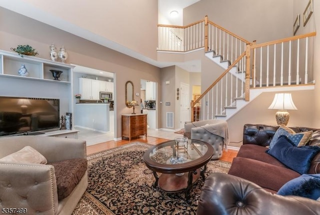 15 Pinehurst Cir, Clinton Twp, NJ 08801 - living area with light wood finished floors, a high ceiling, stairs, and baseboards