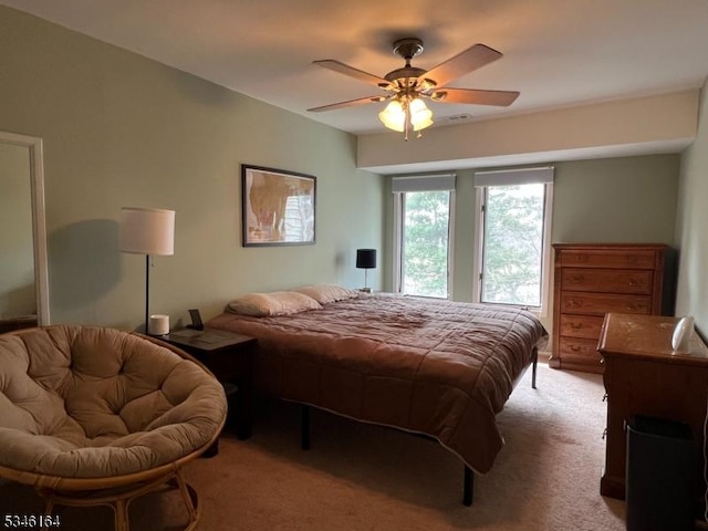 bedroom featuring light carpet and a ceiling fan