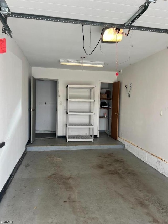 garage featuring a garage door opener and baseboards