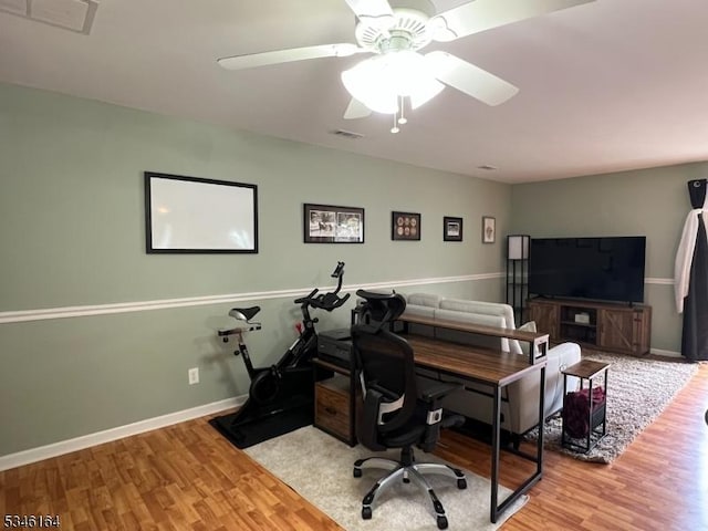 office area featuring wood finished floors, baseboards, and ceiling fan