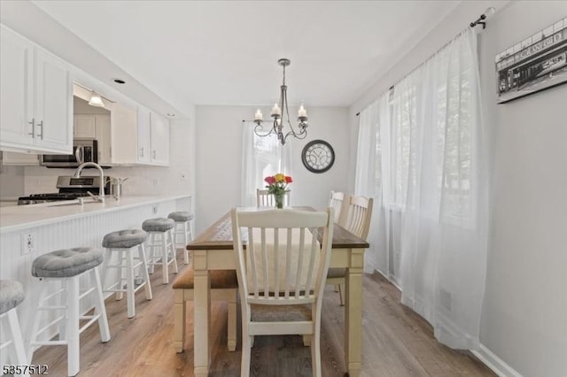 dining room with a chandelier and light wood finished floors