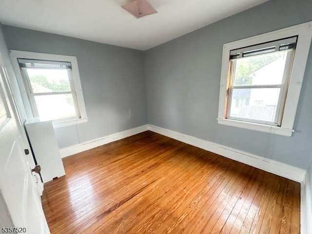 unfurnished room featuring wood-type flooring and baseboards