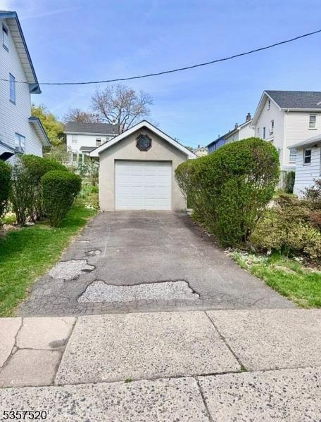 detached garage with asphalt driveway