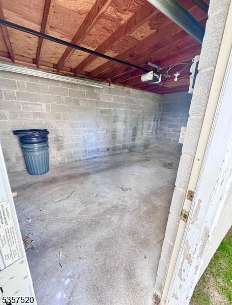 unfinished basement featuring concrete block wall