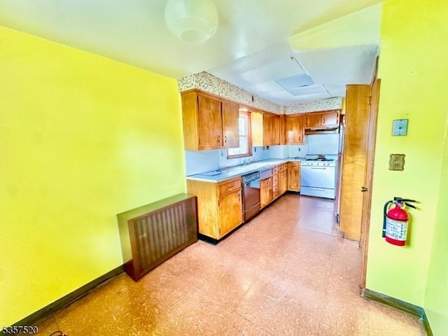 kitchen with white gas range oven, dishwasher, light flooring, light countertops, and baseboards