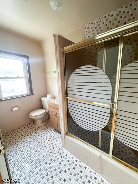 bathroom featuring toilet, a shower stall, and vanity