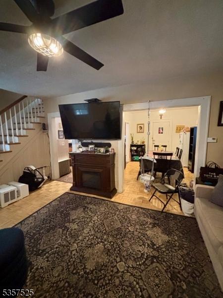 18 Park Dr N, West Orange Twp, NJ 07052 - living room featuring stairway, a ceiling fan, and a fireplace