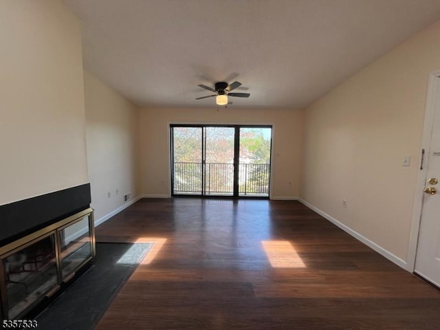 unfurnished living room featuring dark wood-style floors, baseboards, and a ceiling fan