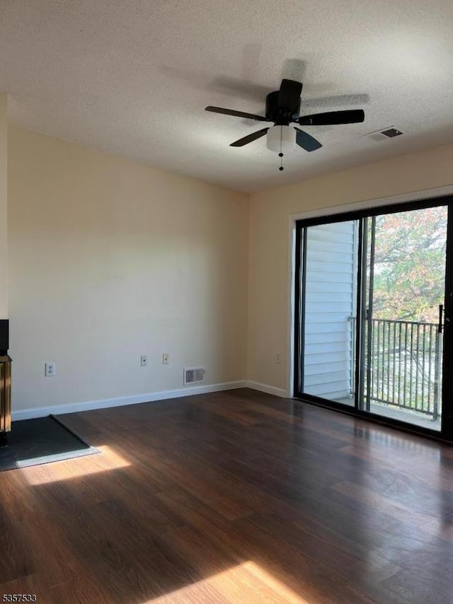 unfurnished room featuring dark wood-style flooring, baseboards, a ceiling fan, and a textured ceiling