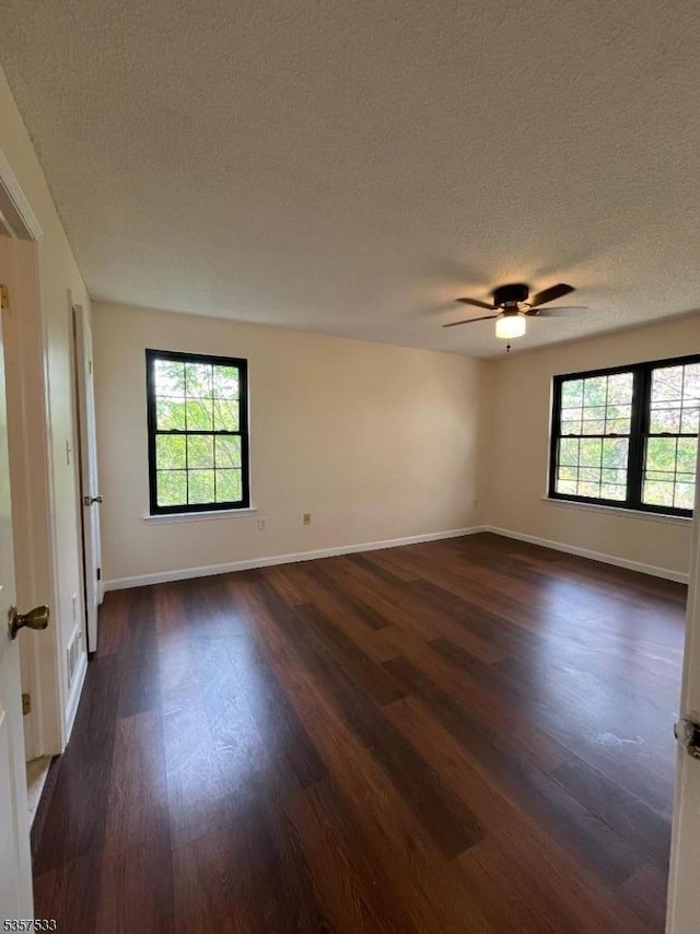 spare room with dark wood-style floors, a textured ceiling, baseboards, and ceiling fan