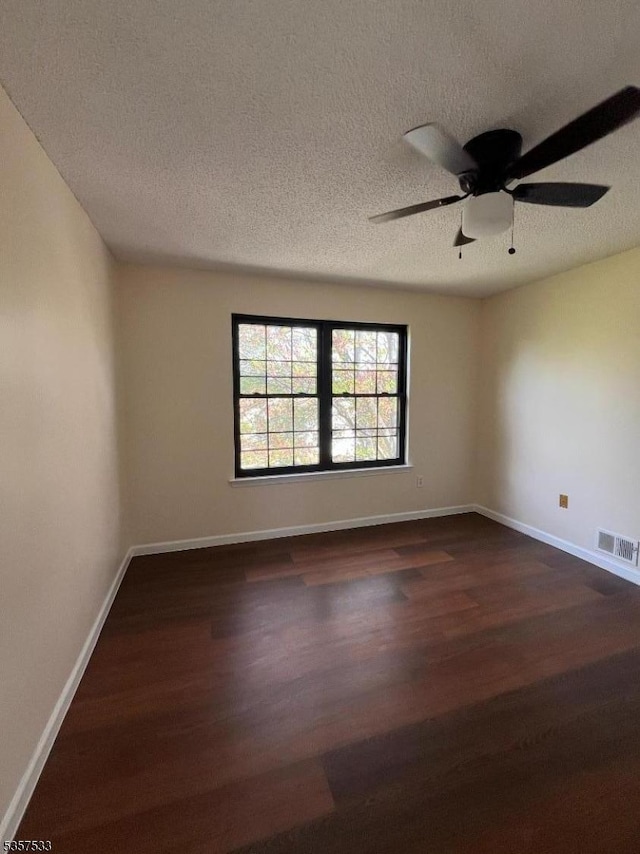 unfurnished room with dark wood finished floors, baseboards, ceiling fan, and a textured ceiling