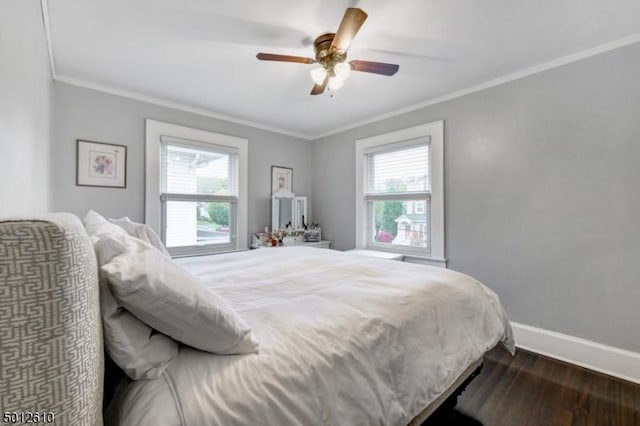 bedroom featuring multiple windows, dark wood-style flooring, crown molding, baseboards, and ceiling fan