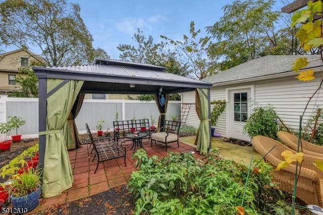 view of patio with a gazebo, outdoor lounge area, and fence