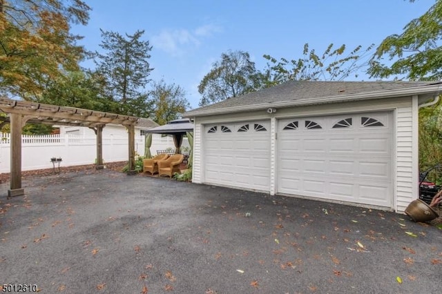 detached garage featuring fence
