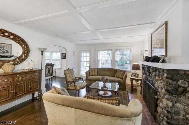 living area featuring a fireplace, coffered ceiling, arched walkways, and beam ceiling