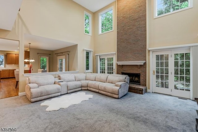 102 Independence Dr, Bernards Twp, NJ 07920 - carpeted living room featuring a towering ceiling, a chandelier, and a brick fireplace