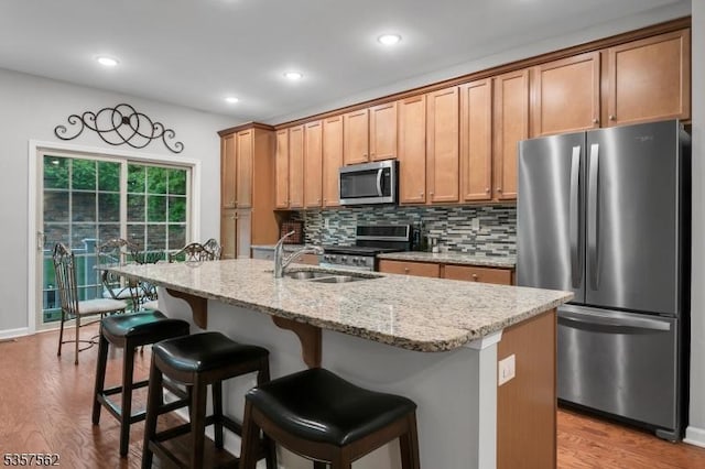 18 Brompton Pl, Randolph Twp, NJ 07869 - kitchen with stainless steel appliances, a sink, an island with sink, light wood-style floors, and tasteful backsplash