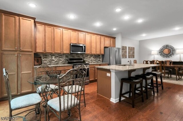 18 Brompton Pl, Randolph Twp, NJ 07869 - kitchen with appliances with stainless steel finishes, a kitchen island with sink, dark wood finished floors, decorative backsplash, and recessed lighting