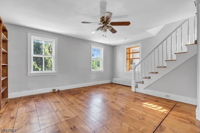 392 Pittstown Rd, Franklin Twp, NJ 08867 - unfurnished living room with radiator heating unit, plenty of natural light, and stairway