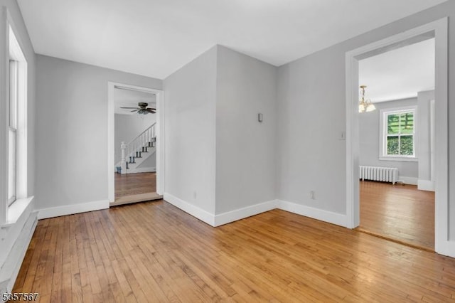 392 Pittstown Rd, Franklin Twp, NJ 08867 - spare room featuring radiator heating unit, light wood-style floors, baseboards, a chandelier, and a ceiling fan