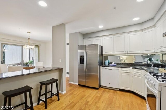 9 Larkin Unit 9, West Orange Twp, NJ 07052 - kitchen with white appliances, a sink, dark countertops, white cabinetry, and recessed lighting