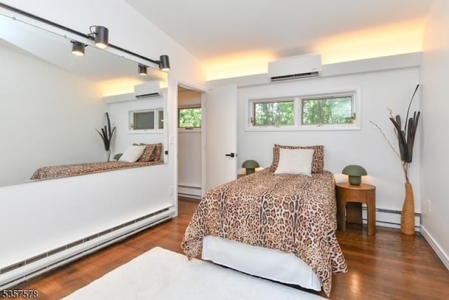 203 Stanhope Rd, Sparta Twp, NJ 07871 - bedroom featuring a baseboard heating unit, an AC wall unit, and wood finished floors