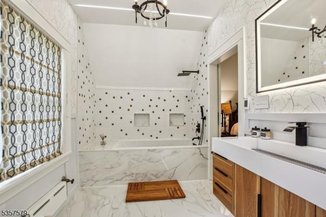 bathroom featuring baseboard heating, a tub with marble appearance, marble finish floors, a shower, and vanity
