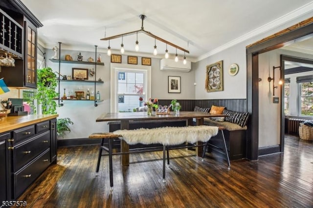 dining room with a wall mounted air conditioner, crown molding, dark wood-style floors, and breakfast area