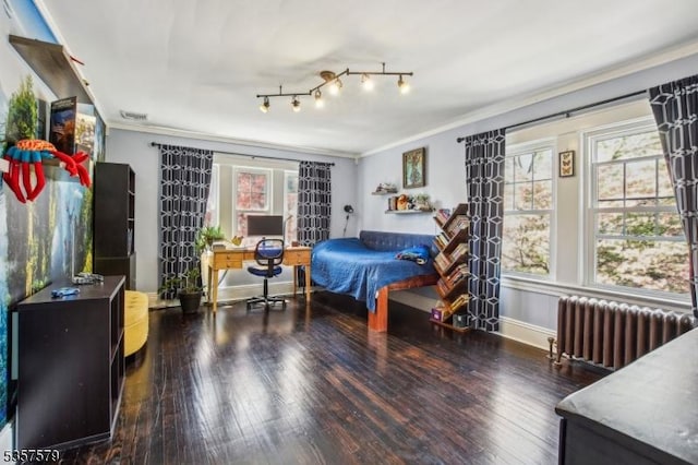 bedroom with radiator heating unit, crown molding, multiple windows, and wood finished floors
