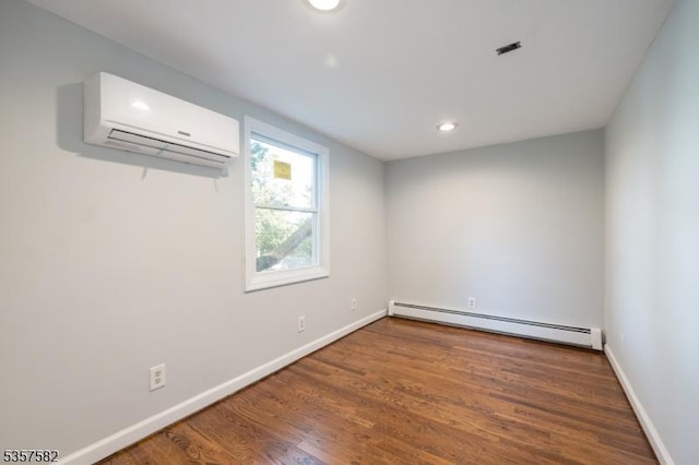 empty room with a baseboard radiator, an AC wall unit, wood finished floors, baseboards, and recessed lighting