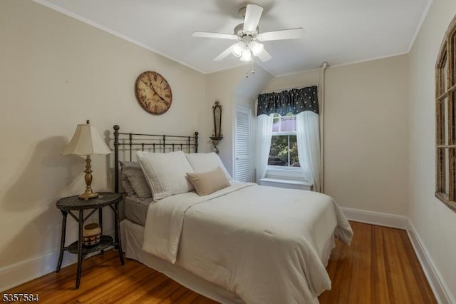 bedroom featuring wood finished floors, baseboards, a ceiling fan, and ornamental molding