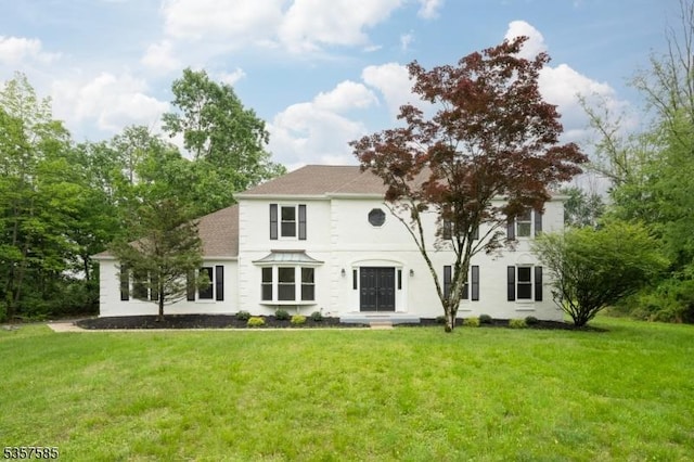 view of front of home featuring a front lawn and roof with shingles