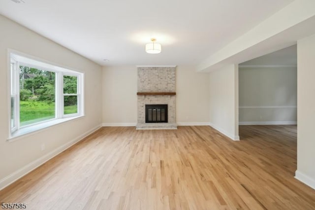 unfurnished living room with light wood-style flooring and baseboards