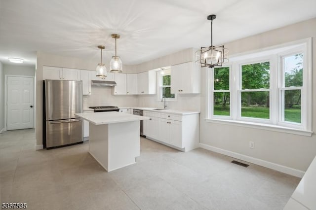 kitchen featuring appliances with stainless steel finishes, a sink, baseboards, and white cabinetry