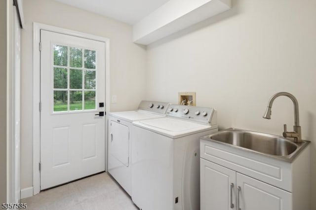 clothes washing area with washing machine and clothes dryer and cabinet space