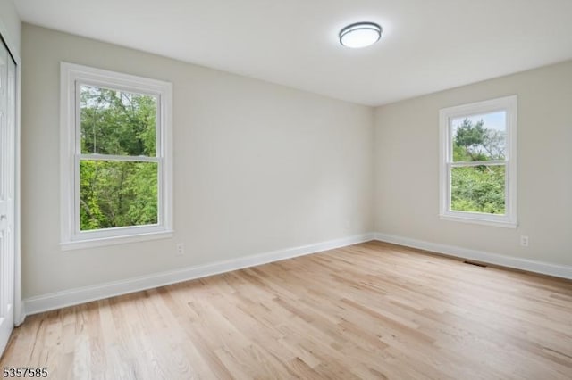 spare room featuring light wood-style flooring and baseboards