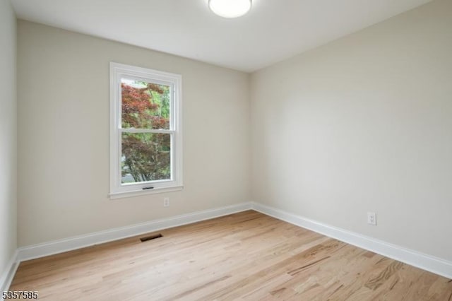 spare room with light wood-style floors and baseboards