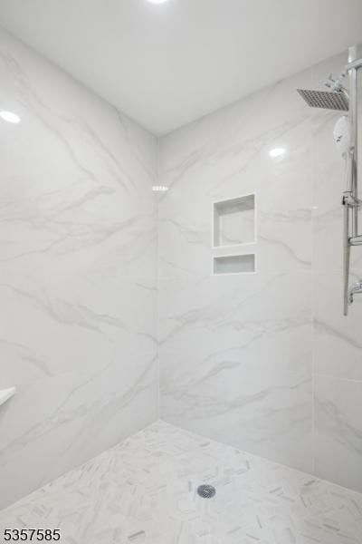 full bath with a marble finish shower