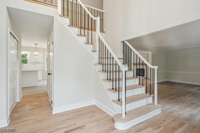 staircase featuring wood finished floors and baseboards