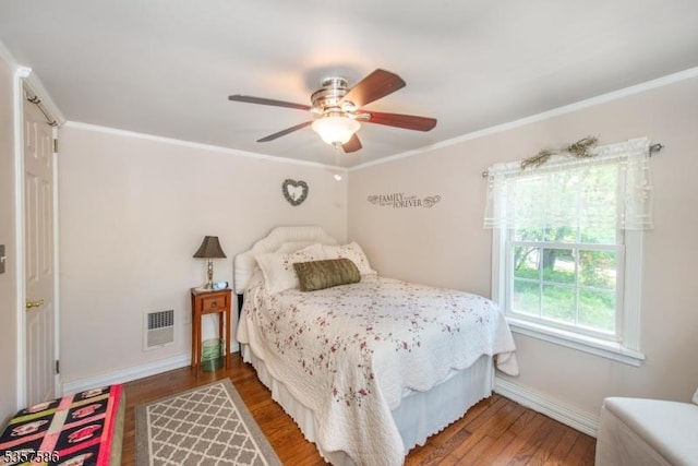 bedroom featuring baseboards, wood finished floors, crown molding, and a ceiling fan