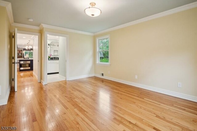 25 Woodcliff Dr, Madison Boro, NJ 07940 - spare room with light wood-type flooring, ornamental molding, a chandelier, and a smoke detector