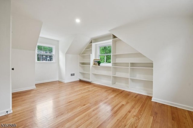 25 Woodcliff Dr, Madison Boro, NJ 07940 - additional living space featuring built in shelves, healthy amount of natural light, vaulted ceiling, and light wood finished floors