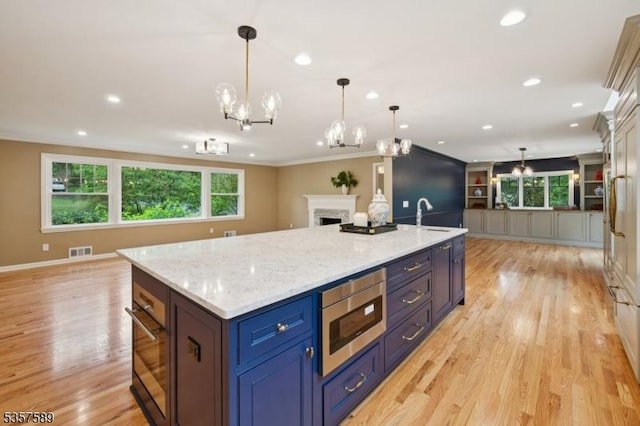 25 Woodcliff Dr, Madison Boro, NJ 07940 - kitchen featuring stainless steel microwave, open floor plan, black oven, ornamental molding, and light wood-type flooring