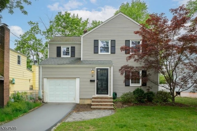 traditional-style home with asphalt driveway, entry steps, an attached garage, and a front lawn