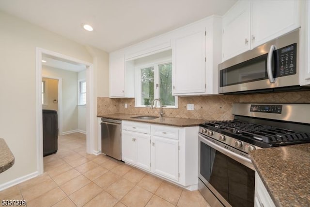 kitchen with stainless steel appliances, decorative backsplash, white cabinetry, a sink, and recessed lighting