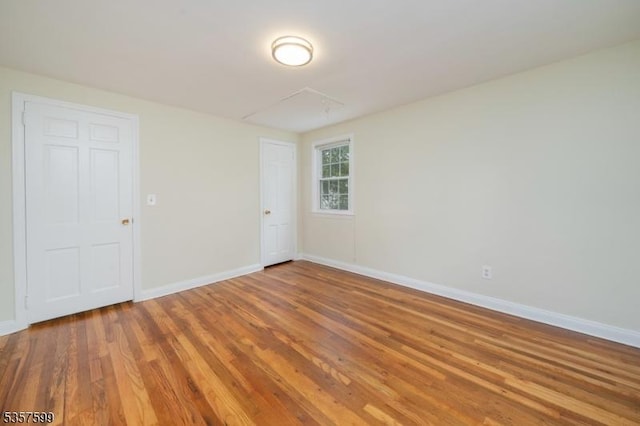 empty room with wood finished floors and baseboards