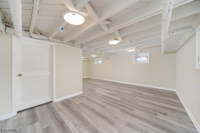 basement featuring light wood-type flooring and baseboards
