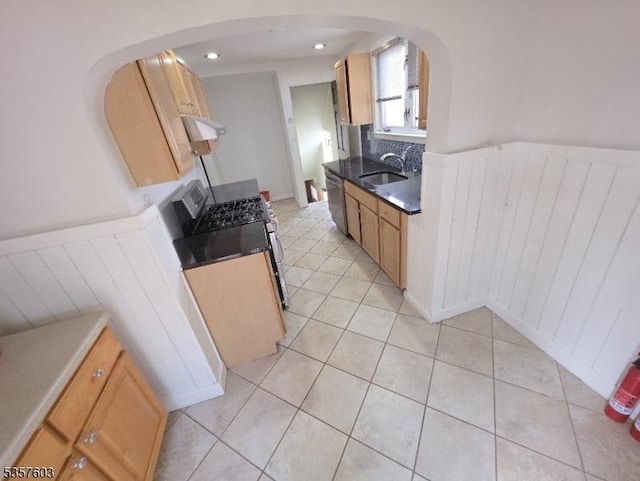 280 Fitzpatrick St, Hillside Twp, NJ 07205 - kitchen with arched walkways, a sink, wainscoting, light tile patterned flooring, and stainless steel dishwasher