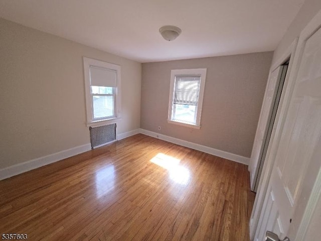 280 Fitzpatrick St, Hillside Twp, NJ 07205 - empty room with plenty of natural light, radiator, wood finished floors, and baseboards
