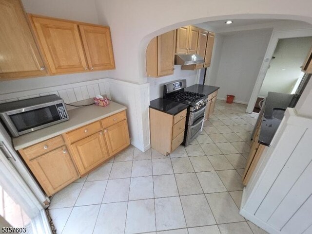 280 Fitzpatrick St, Hillside Twp, NJ 07205 - kitchen with stainless steel appliances, under cabinet range hood, arched walkways, light tile patterned floors, and light brown cabinets